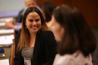 2 females discussing while sitting at a conference table